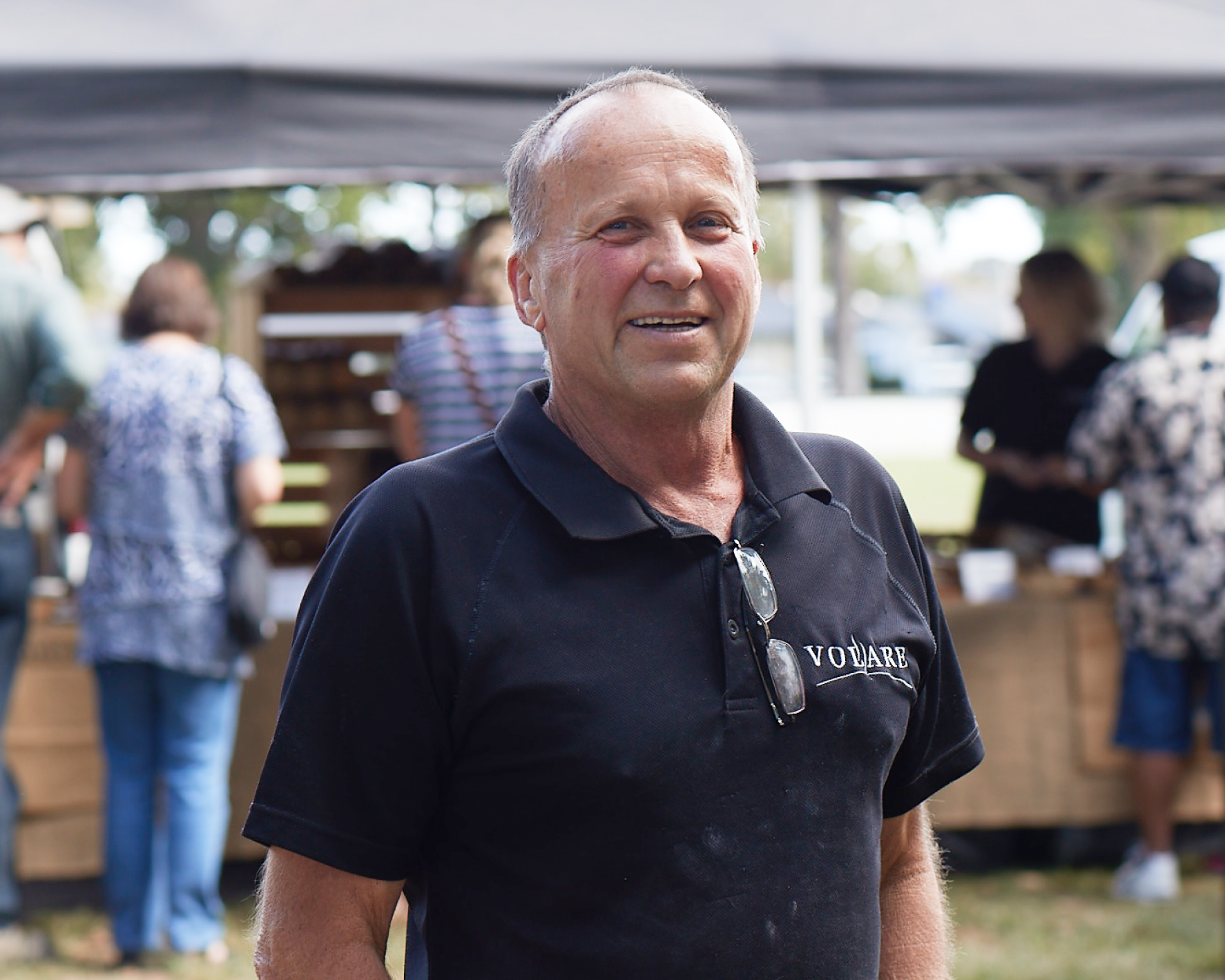 A man dressed in a black shirt, smiling and posing for the photo.